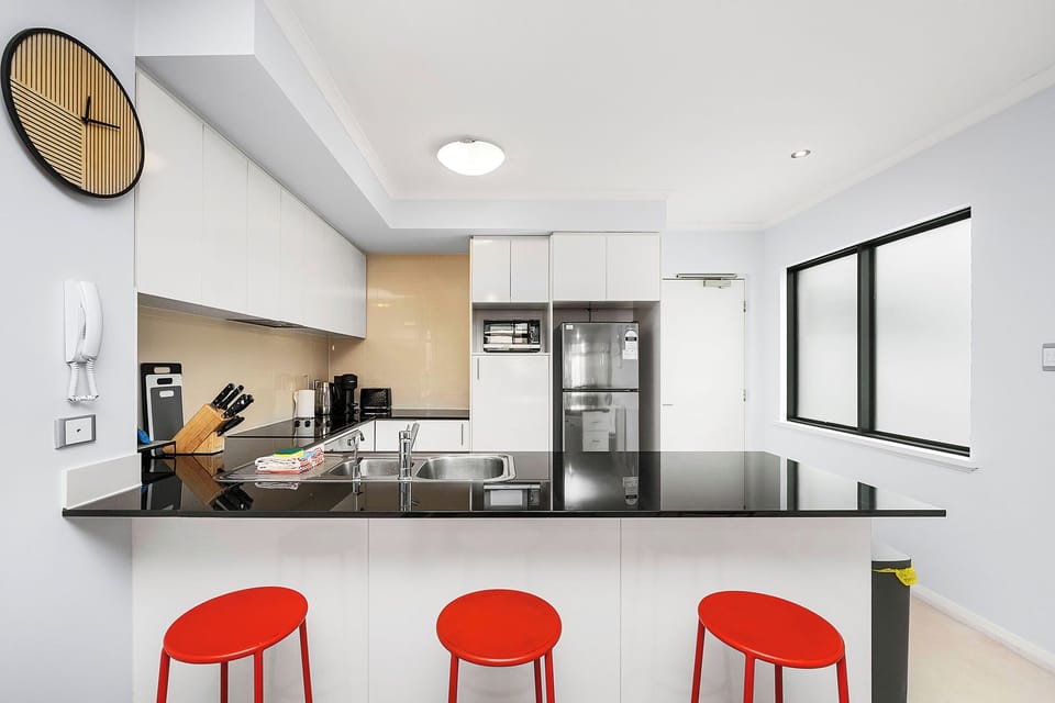 Sleek kitchen with black countertops and modern appliances.