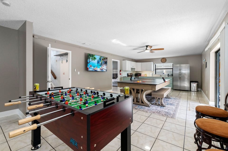 This open-concept area is perfect for family fun, with a full kitchen, foosball, and a convertible ping pong/dining table—plus sliding doors that lead right to the backyard.
