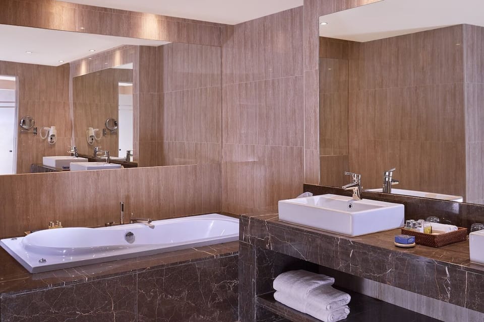 Refresh in a sleek bathroom with deep soaking tub.