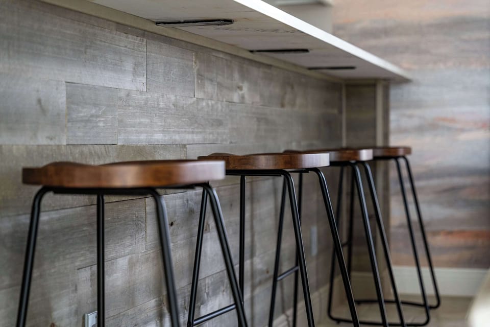 Chic wooden barstools and a sleek counter create the perfect spot for morning coffee, casual dining, or evening cocktails.