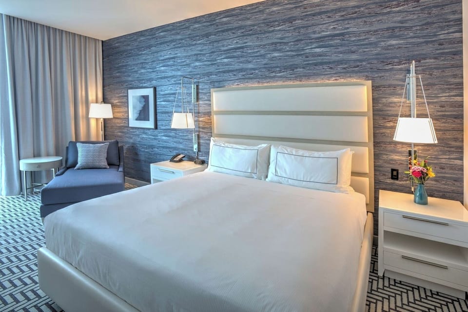 Sink into hotel-soft linens beneath warm, relaxing bedside lighting.