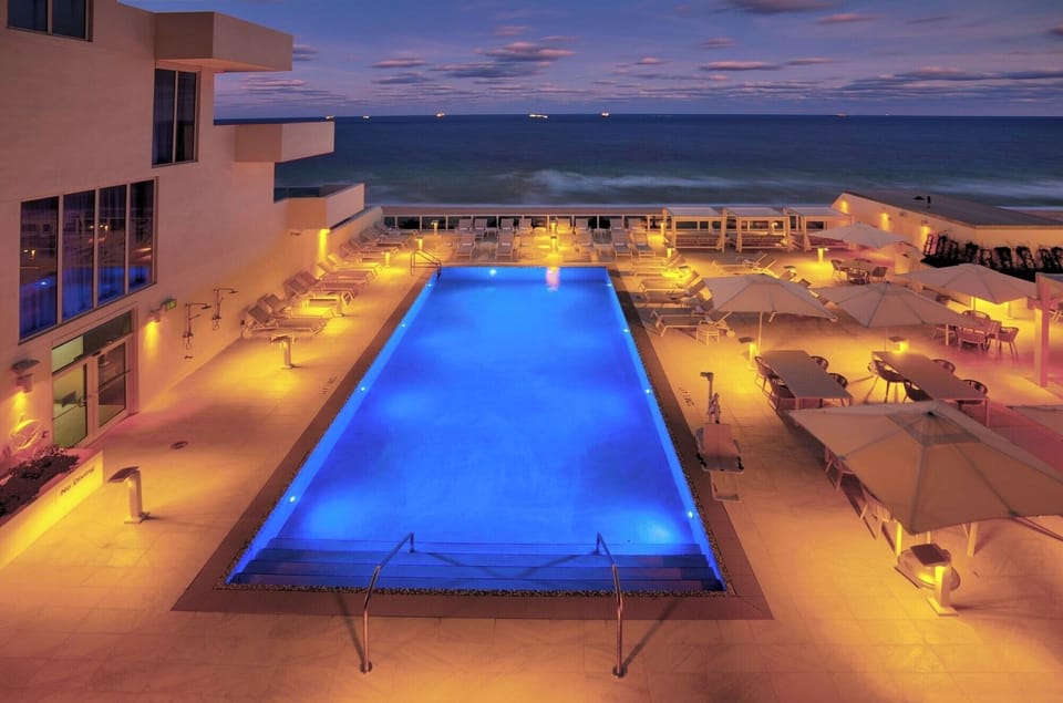 Unwind after dark in a glowing pool above the ocean.