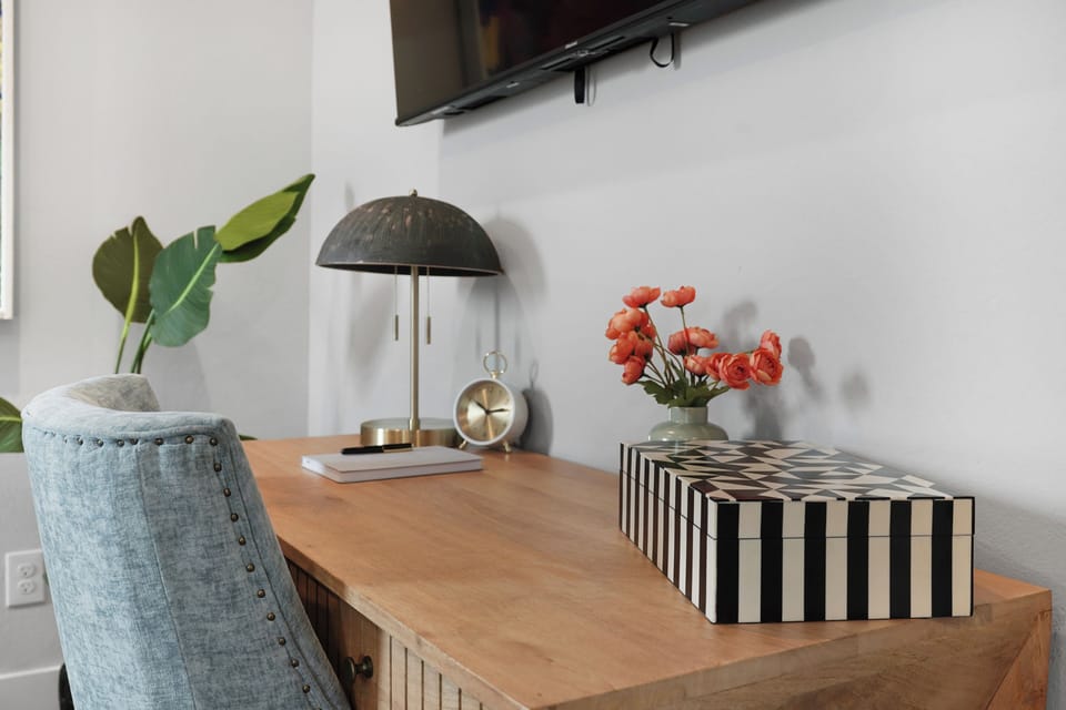 Work desk with lamp, chair, and mounted TV—ideal for remote work