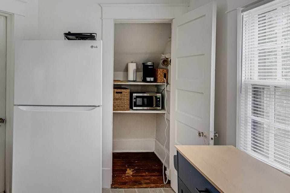 Kitchen with white LG refrigerator and an open pantry with appliances.