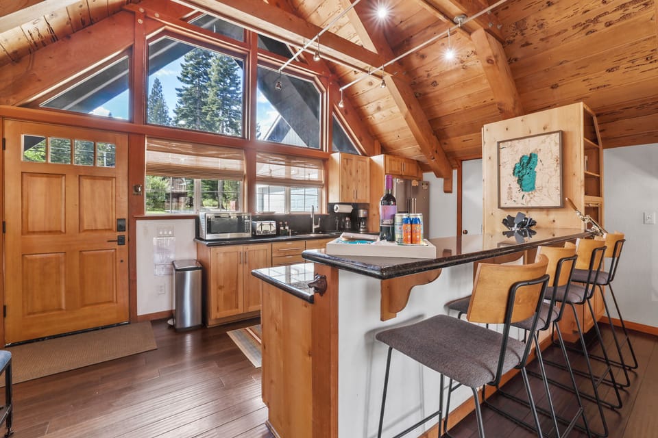 Open-concept kitchen with bar seating and beautiful vaulted wood ceilings.