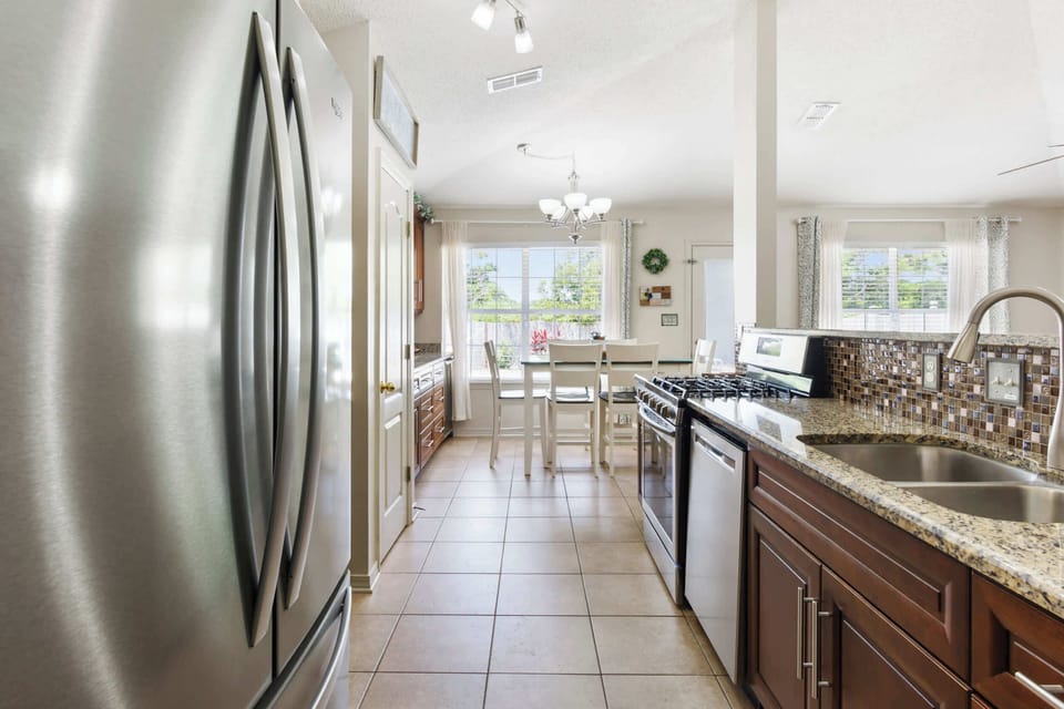 Fully equipped kitchen with gas range stove, granite counters, stainless appliances and lots of prep space for meals, snacks, and game nights