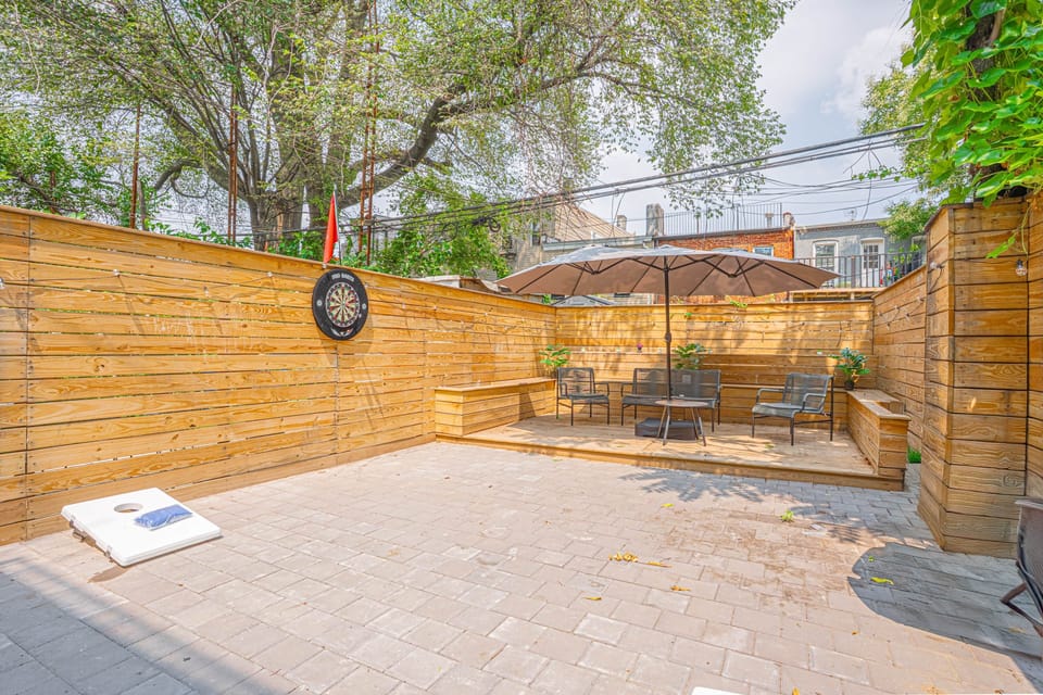 Private patio featuring ample seating, shade umbrella and outdoor games for fun and relaxation