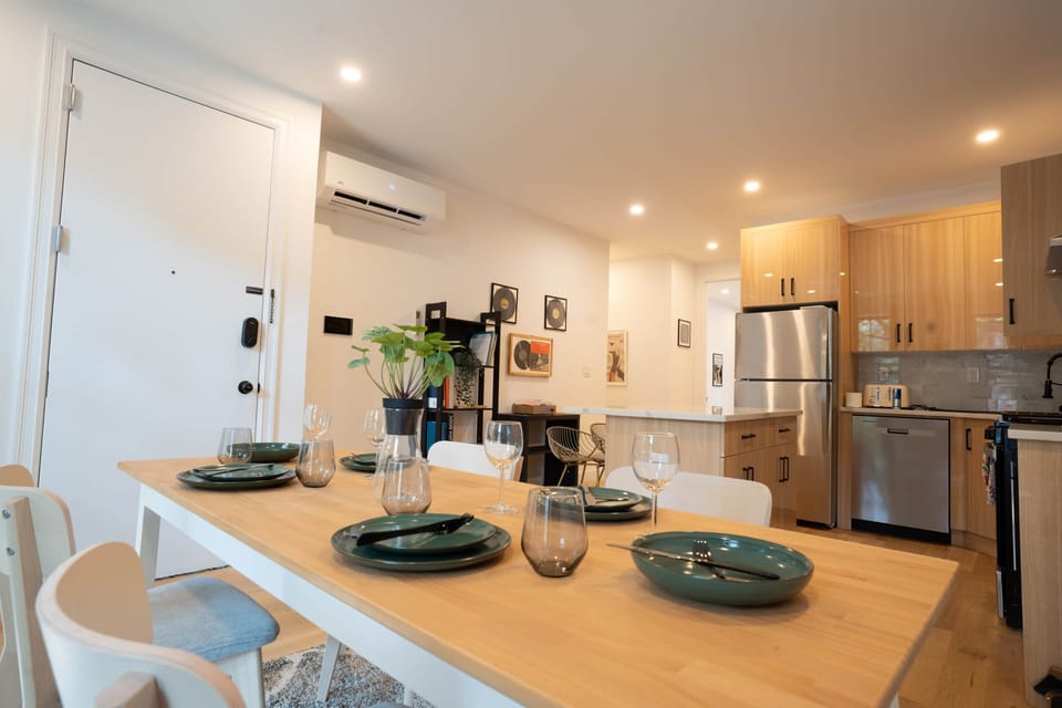 Elegant dining area with modern table setting and open layout connecting kitchen and living space