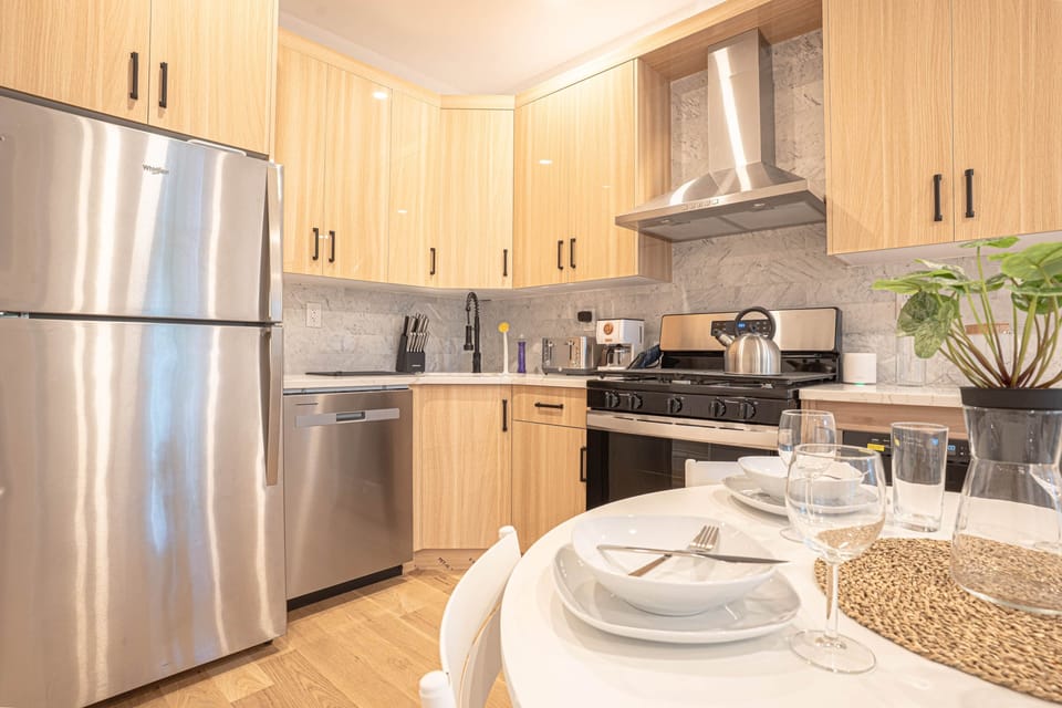 Modern kitchen with stainless steel appliances, spacious counters and cozy dining setup for meals.