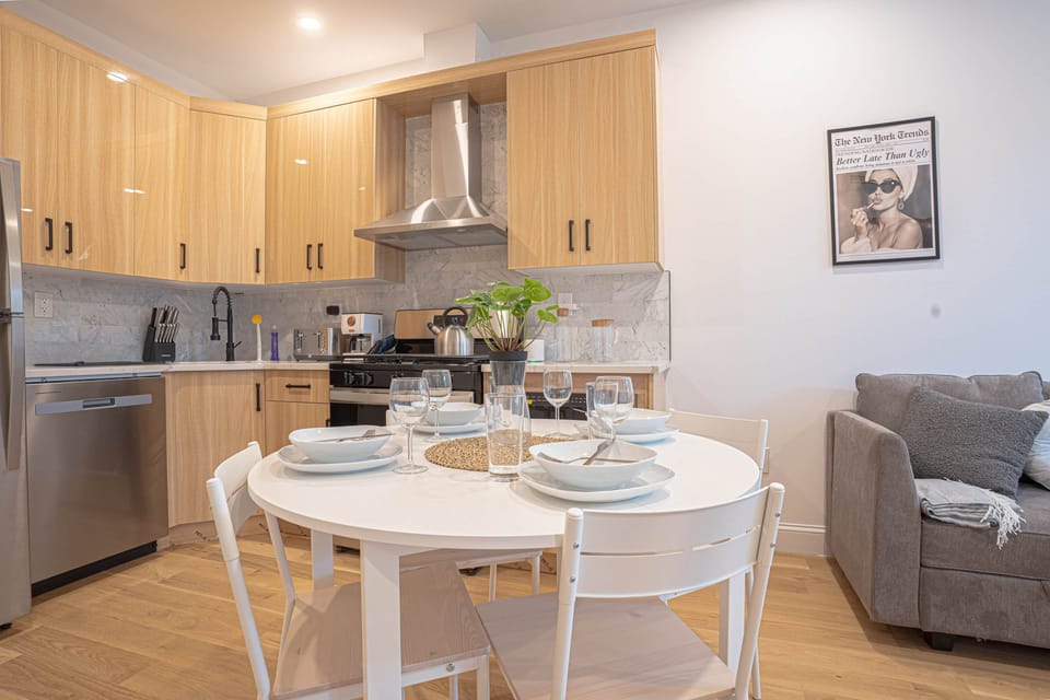 Modern kitchen with dining set and cozy sofa, stainless appliances and open layout.