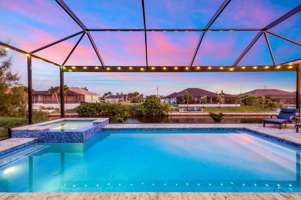 Unwind in the sparkling heated pool and spa with ambient string lighting and serene water views — pure vacation bliss