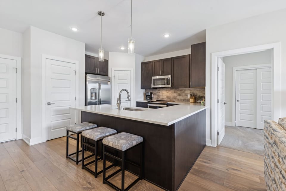 Full kitchen and bar on island with seating for 3 people.