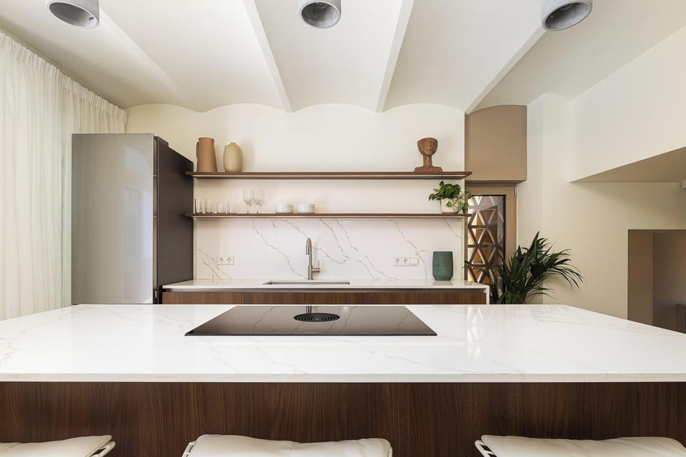 The fully equipped kitchen features all modern appliances, and adjacent to it is the dining area, comfortably seating up to ten guests