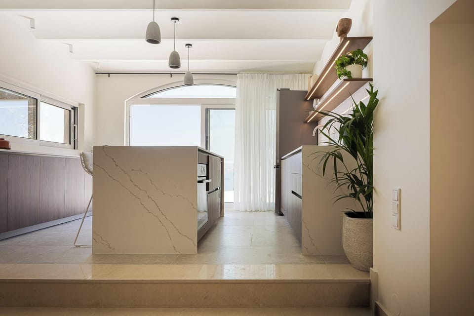 The fully equipped kitchen features all modern appliances, and adjacent to it is the dining area, comfortably seating up to ten guests
