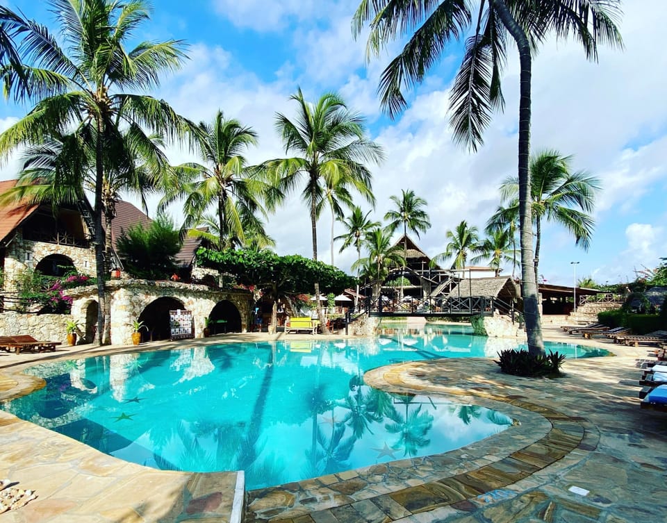 Dive into sparkling lagoon pool beneath swaying palm trees.