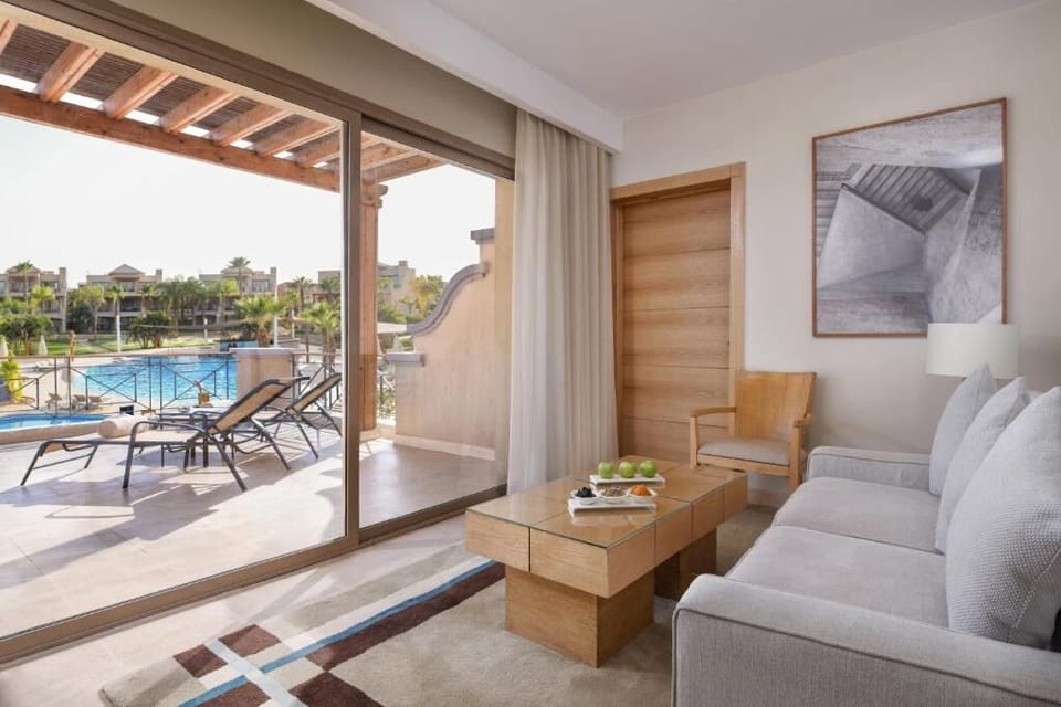 Lounge with a drink as terrace doors frame the pool.