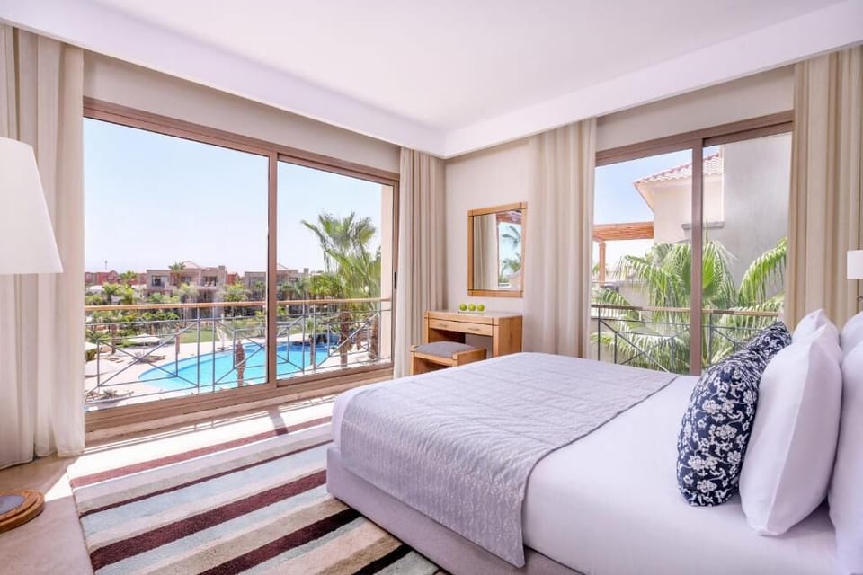 Wake up to sunshine and serene pool views from bed.