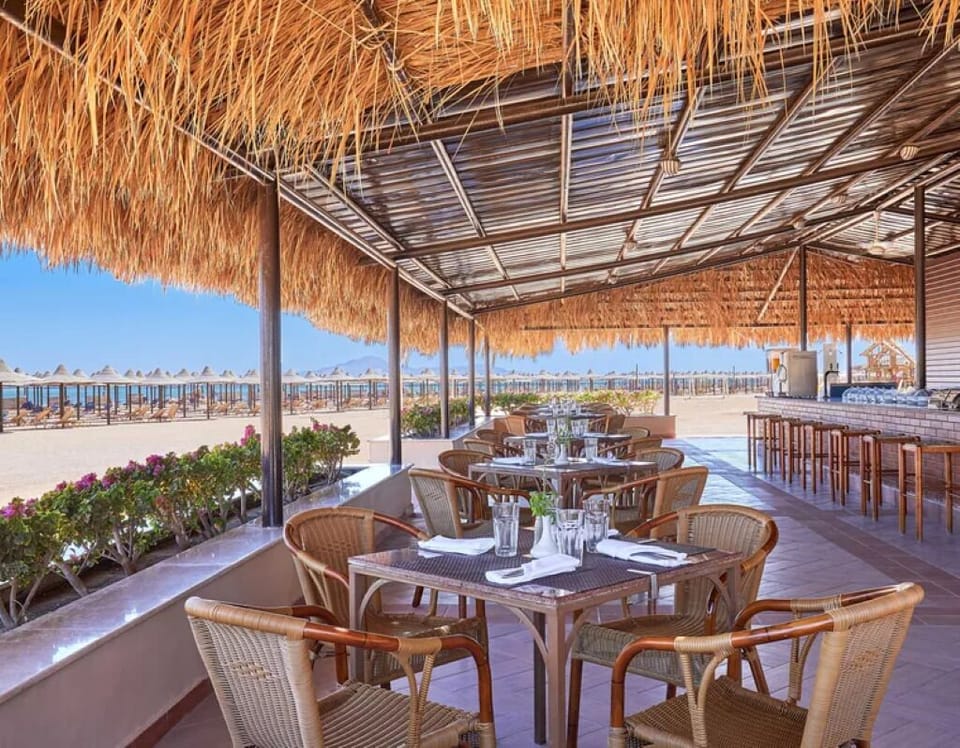 Taste seaside flavors at a shaded bar beside the beach.
