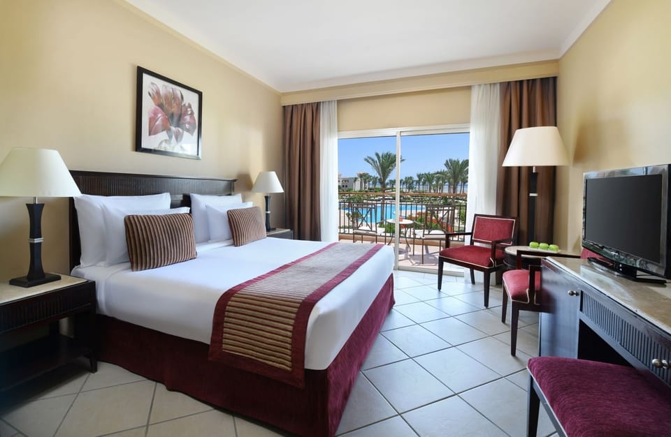 Relax on plush linens as daylight pours in from the balcony.
