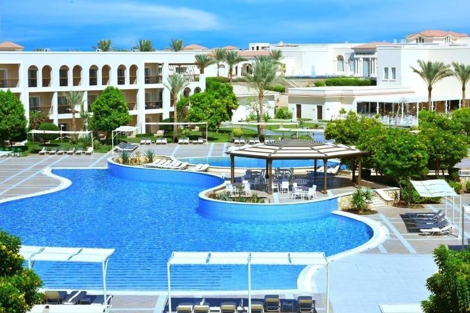 Wander through landscaped paths framing a sparkling resort pool curve.