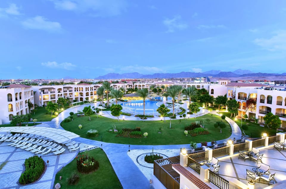 Wander illuminated pathways around lush lawns and shimmering water.