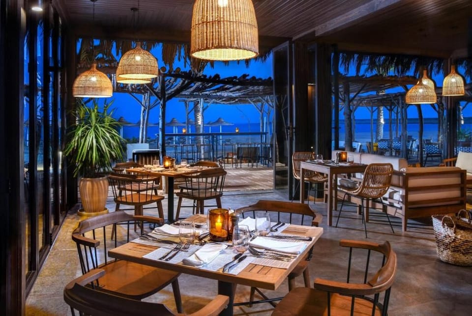 Dine by lanternlight as the sea air cools the night.