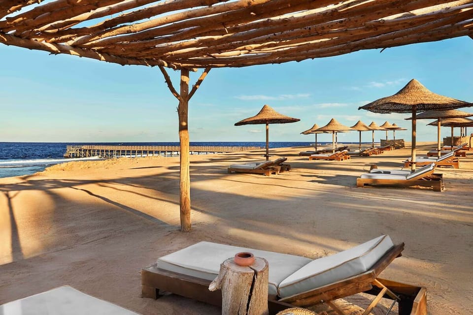 Unwind on the sandy shoreline beneath breezy shaded cabanas.