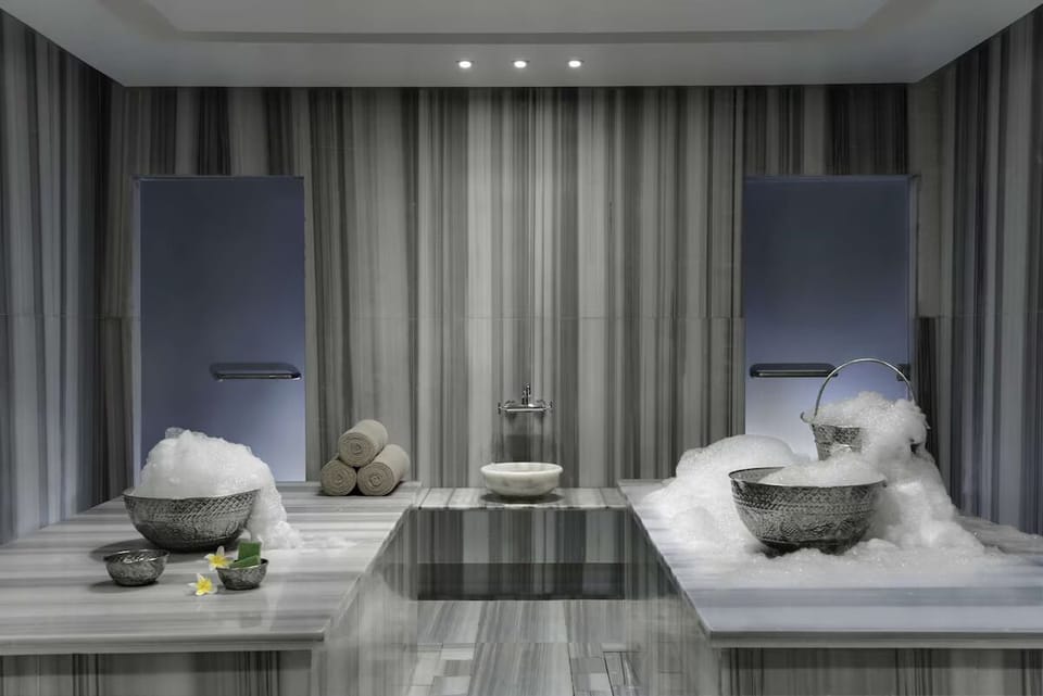 Refresh in the steamy hammam ritual with warm marble comfort.