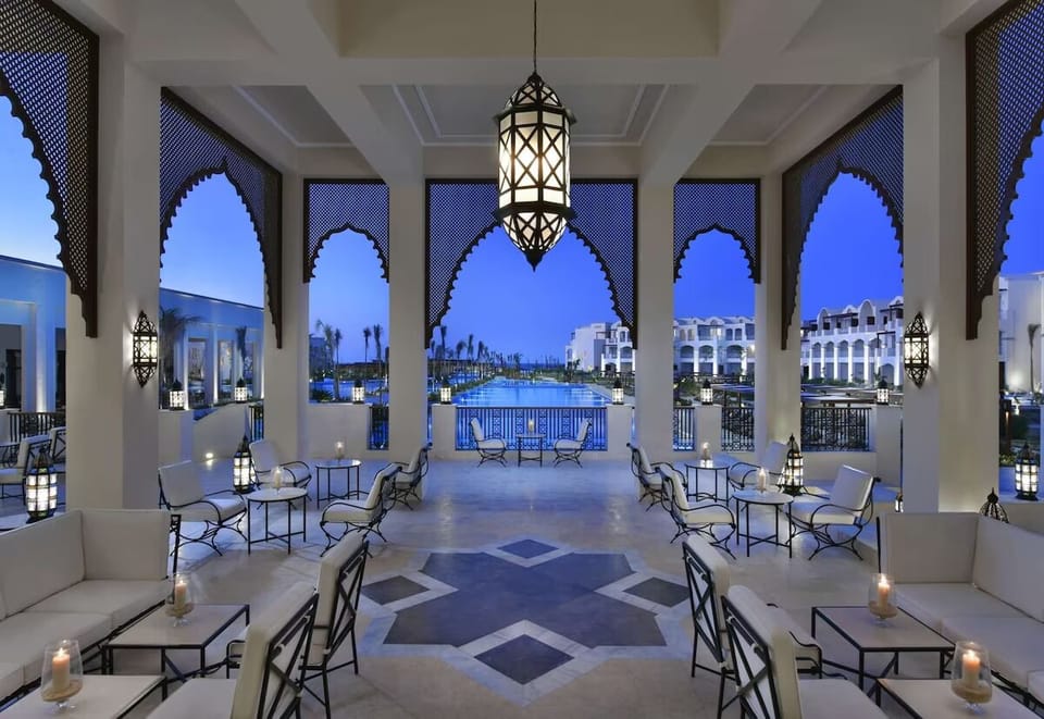 Sip cocktails under glowing arches with dreamy waterfront views.