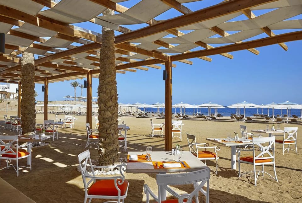 Dine barefoot by the sea under breezy shaded pergolas.