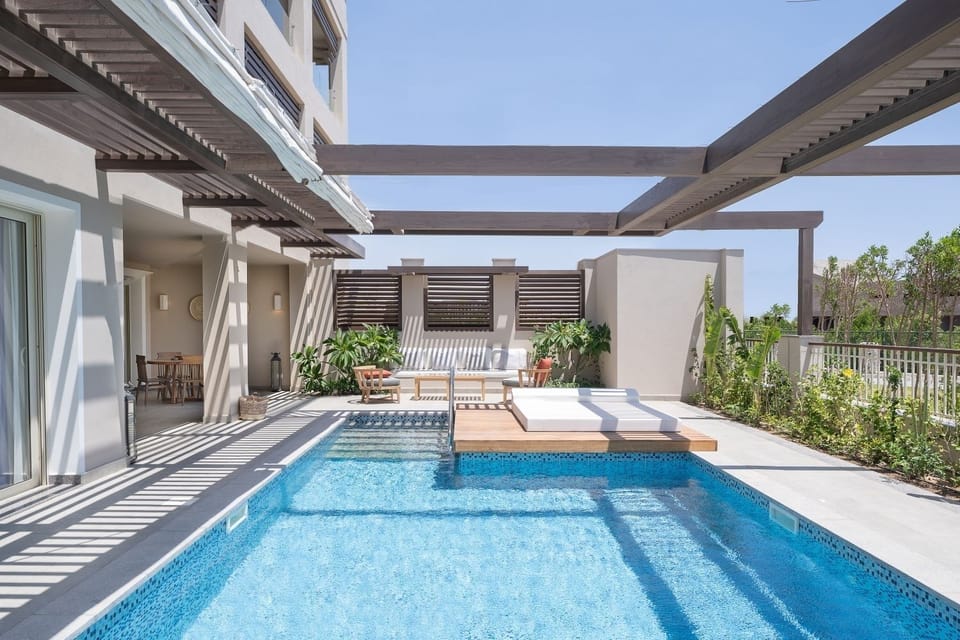 Dive into your private pool beneath breezy shaded pergolas.