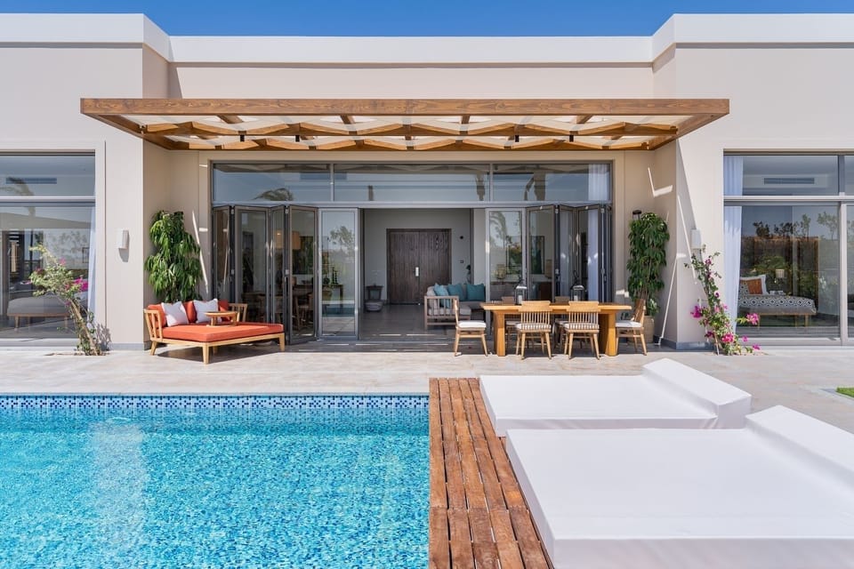 Lounge poolside with cushioned daybeds and open-air comfort.
