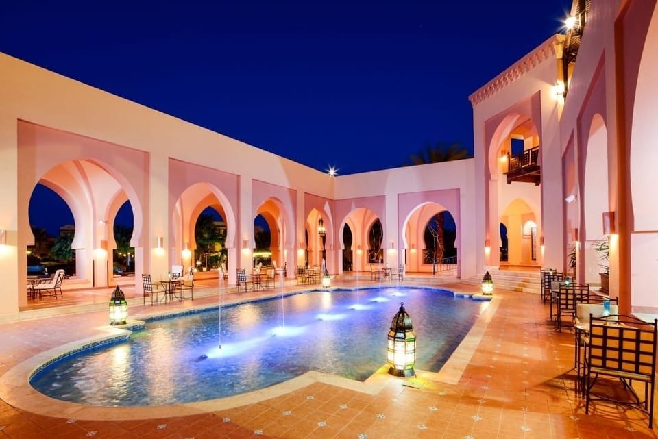 Dive into a lantern-lit pool nightscape under glowing arches.