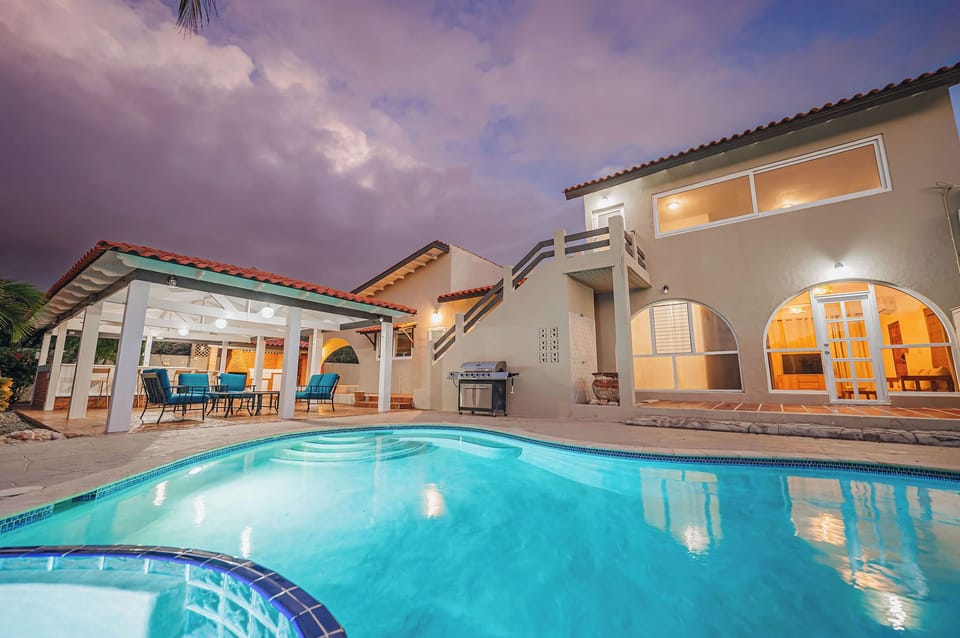 Resort-style pool with evening lighting and spacious deck seating
