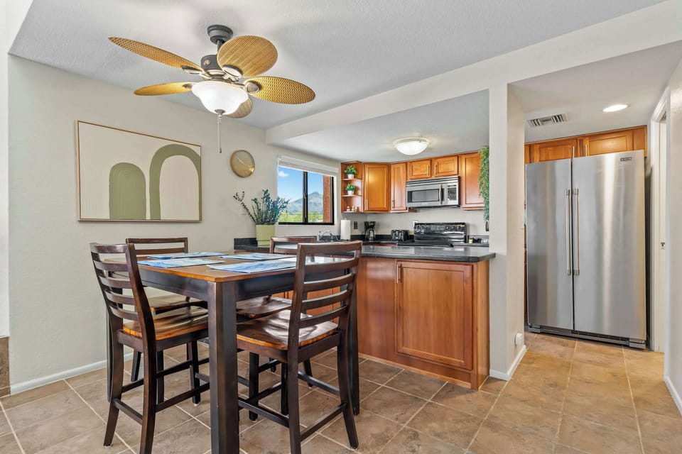 Gather around for meals or game night in this bright dining area, featuring a cozy high-top table, modern lighting, and easy flow into the fully equipped kitchen.