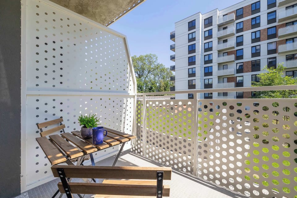 A sunny balcony with a lounge chair and modern railing design. Perfect for enjoying fresh air in privacy.