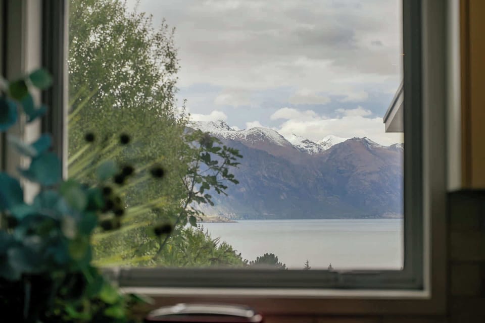 Kitchen window view of snow-capped mountains and the lake
