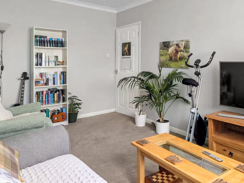 Lounge area with bookshelf and exercise bike