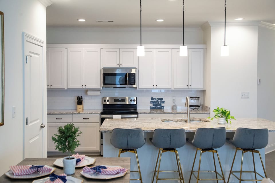 Kitchen with 4 barstools and table that seats 4.