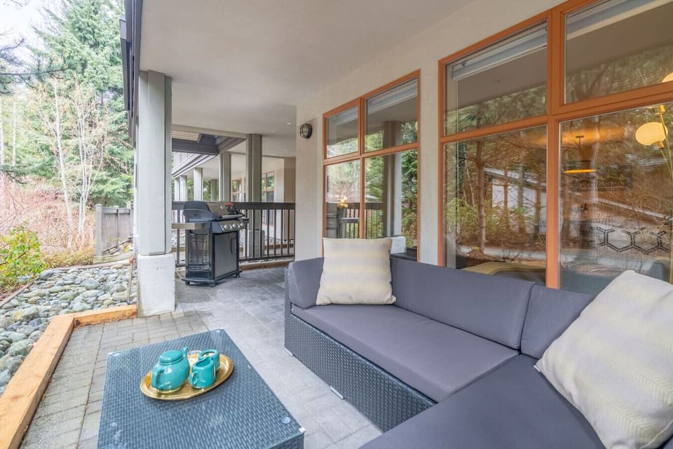 Spacious outdoor terrace with cushioned seating and a Weber BBQ.