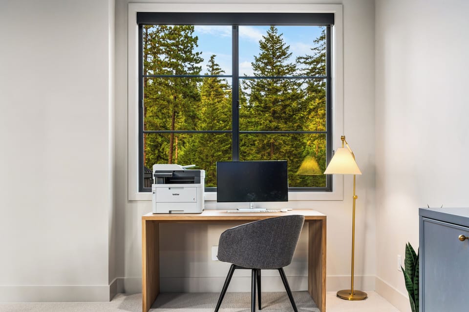 Settle in for focus — a dedicated desk, monitor, and printer at the ready.