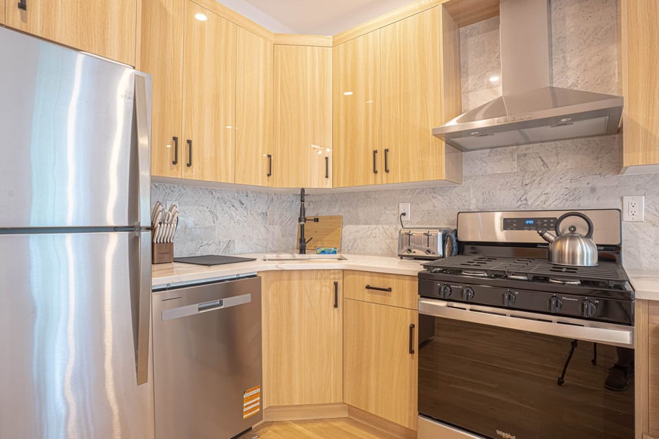 Modern kitchen with marble backsplash and full stainless steel appliances