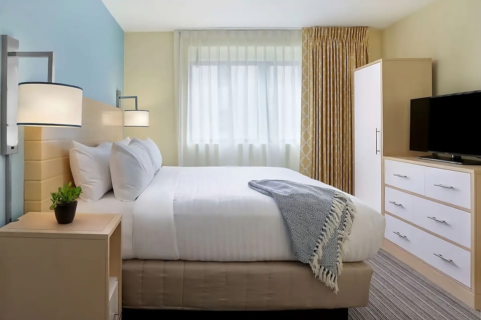 Unwind in a sunlit bedroom with crisp linens and calm tones