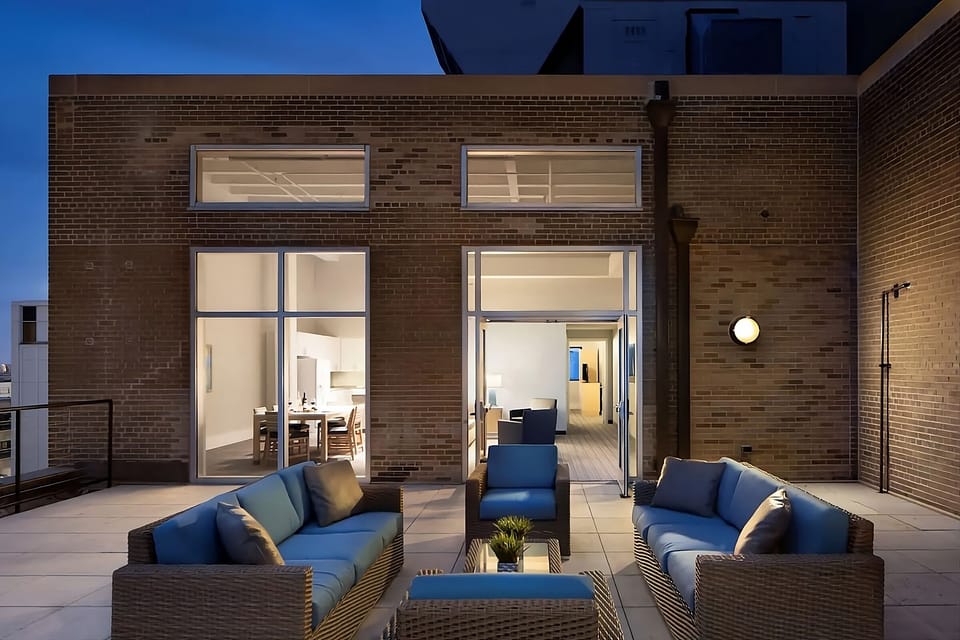 Lounge outdoors at dusk with city breezes and cozy seating.