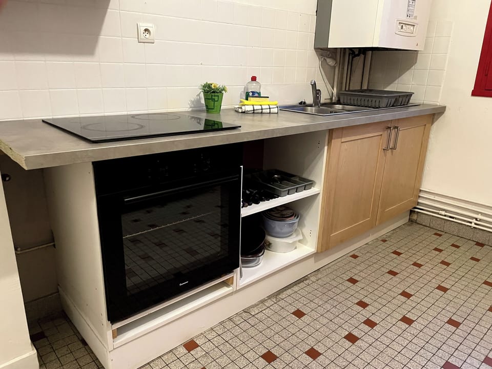 Kitchen with windows and small balcony looking out to car park and Pic du Gar mountains