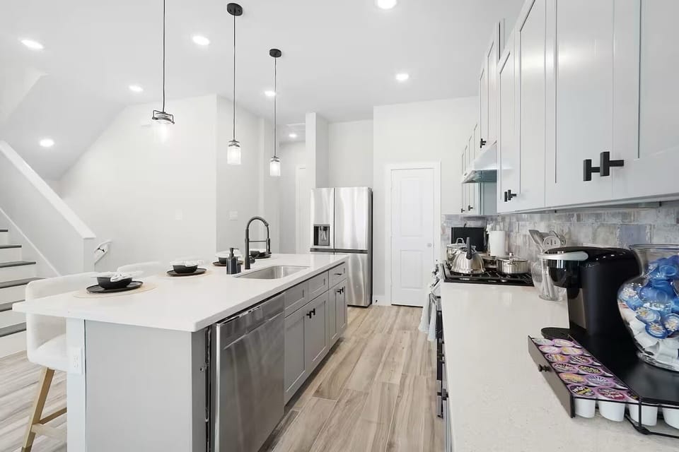 Bright modern kitchen with island seating, sleek gray cabinetry, and dining area