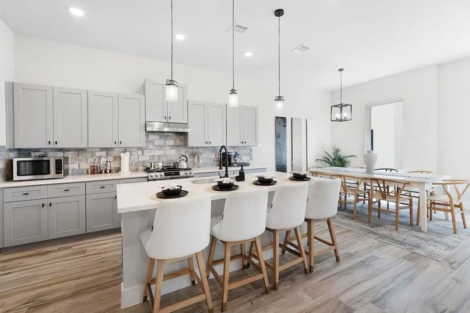 Spacious modern kitchen with island seating and dining area for shared meals.