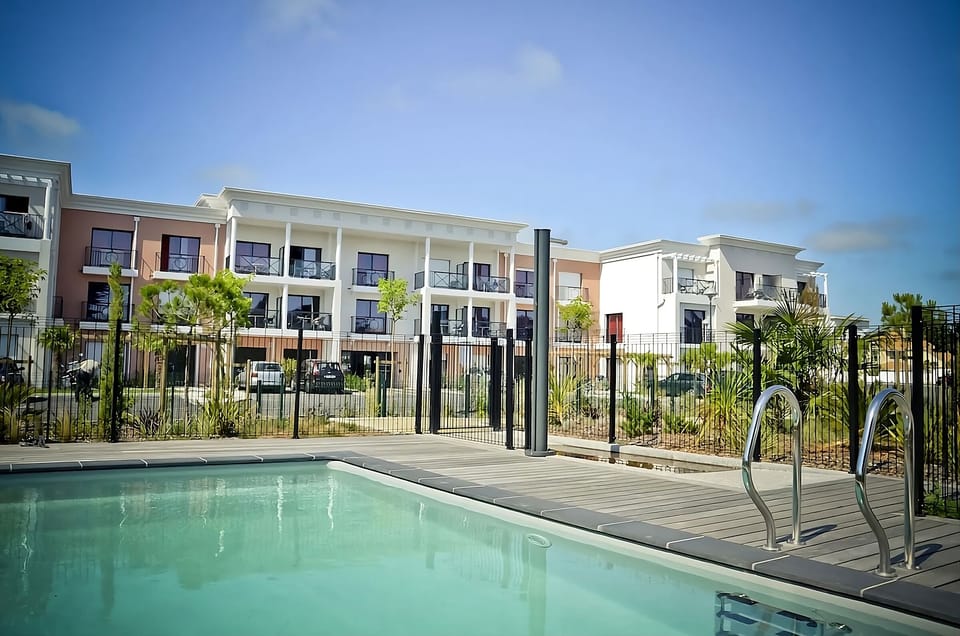 Dive into sunlit serenity beside the sparkling outdoor pool.