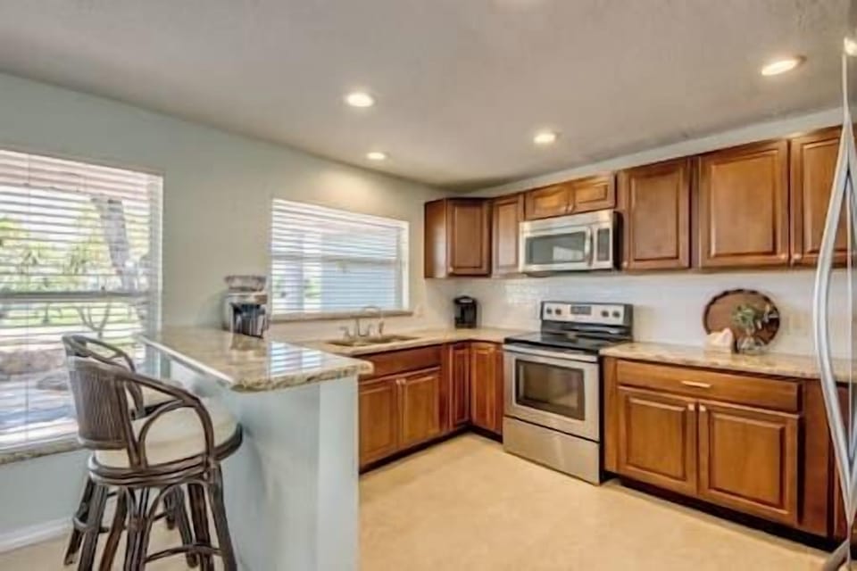 This fully equipped kitchen features stainless appliances and granite countertops.