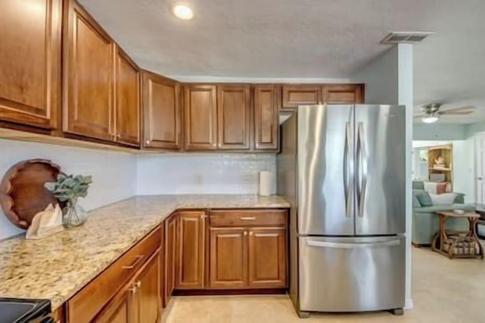A large stainless refrigerator with ice maker completes the kitchen.